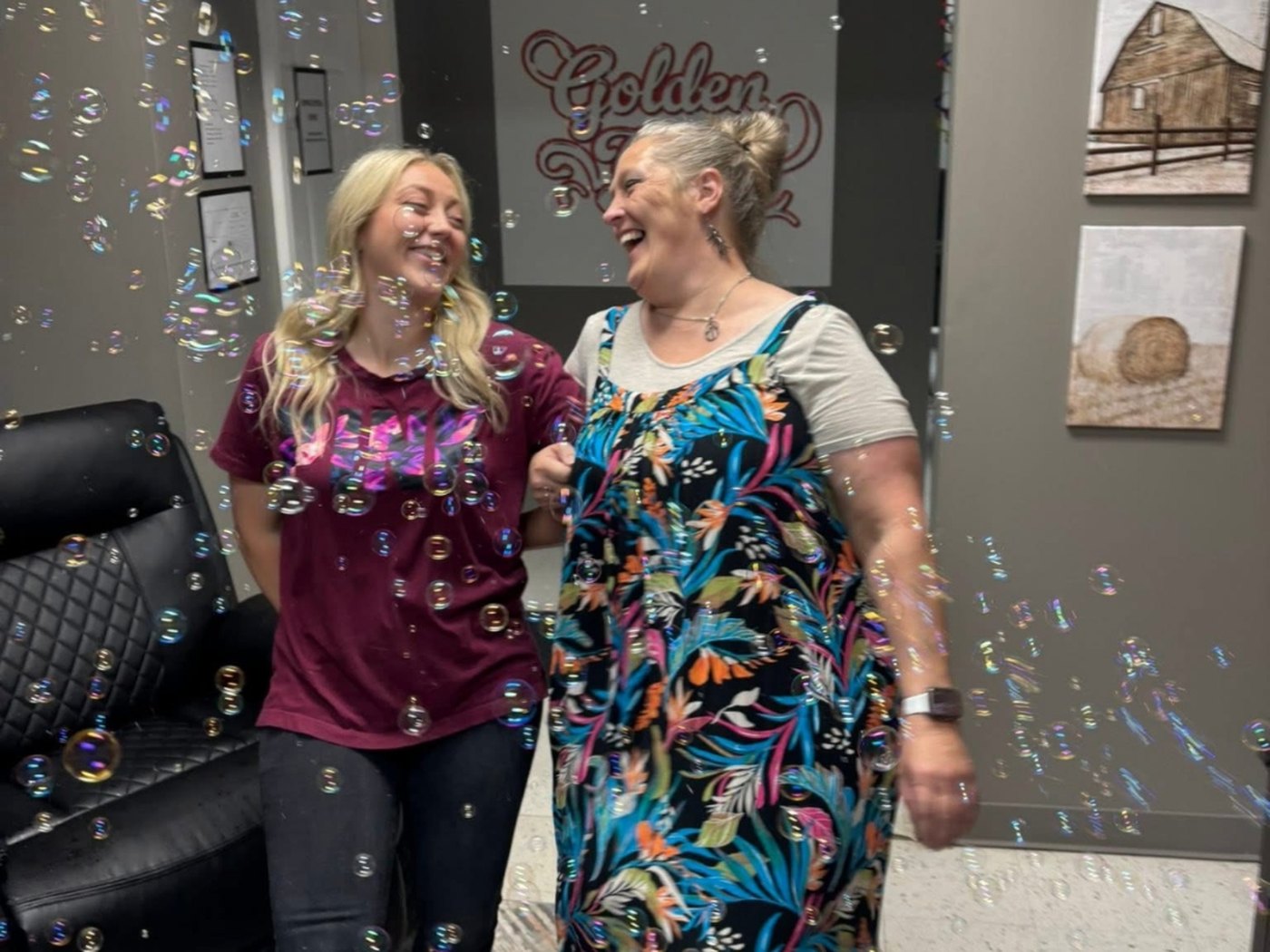 Two Golden Years staff members laughing together among floating bubbles